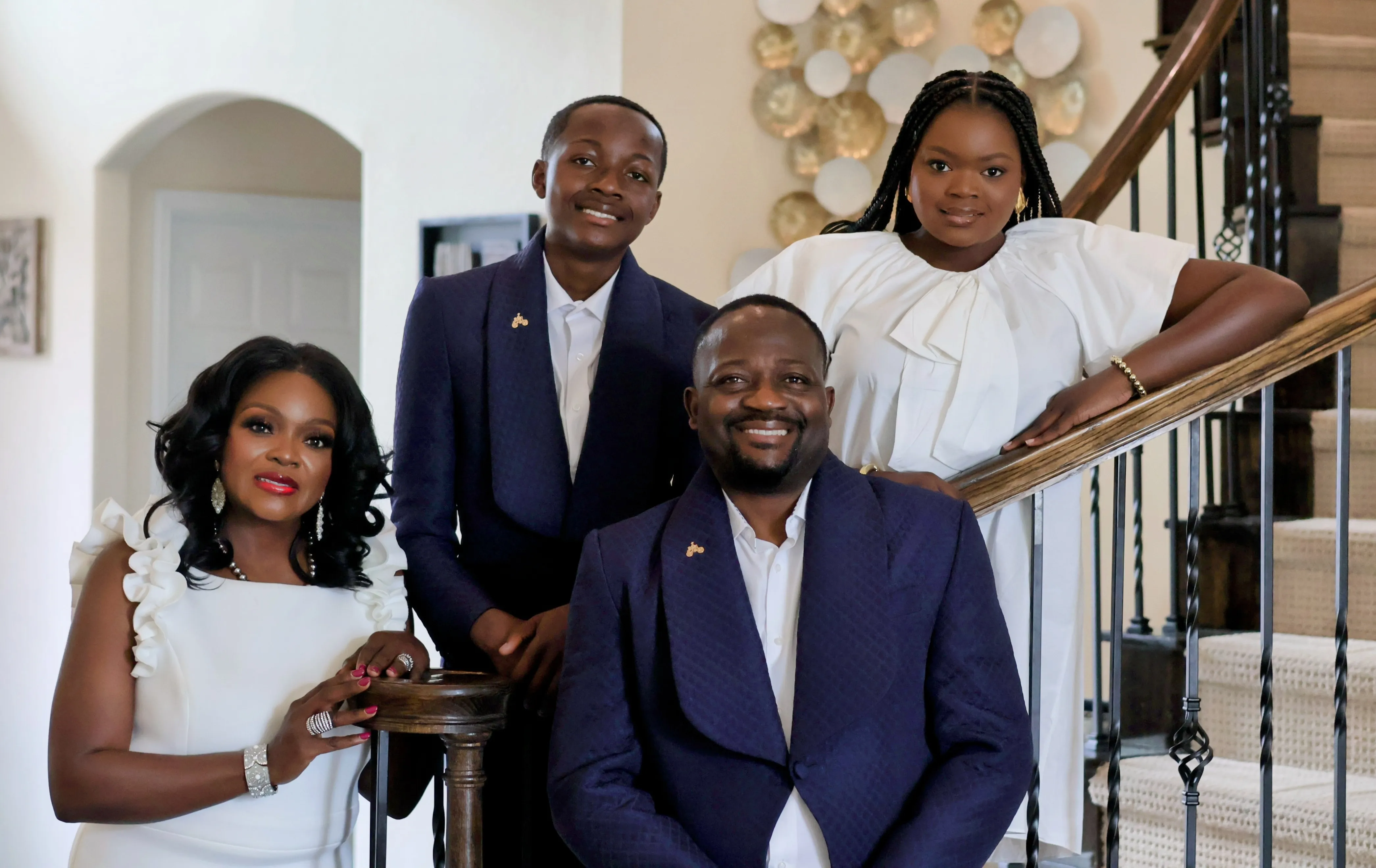 Family portrait - four people posed on staircase in navy and white