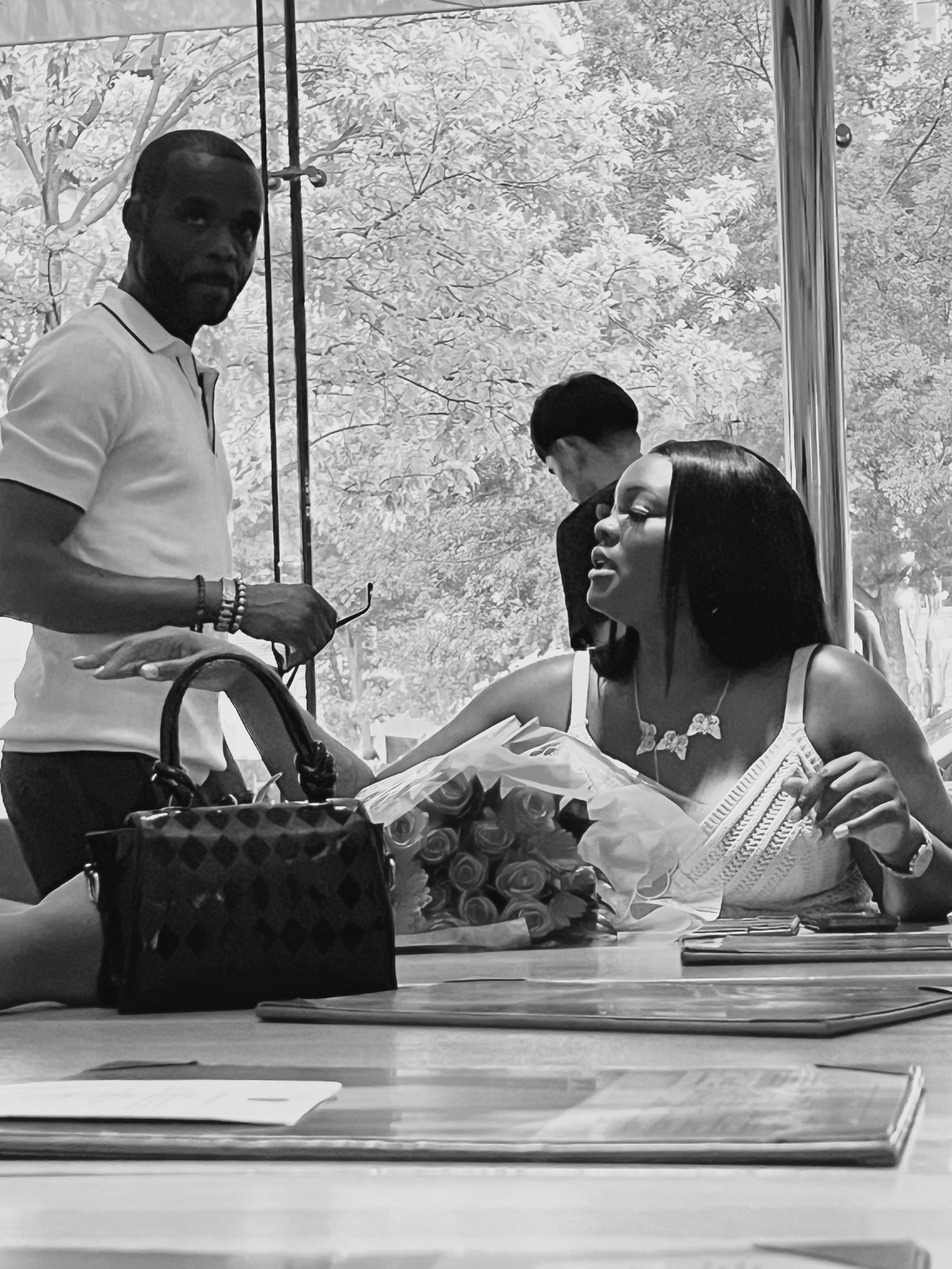 B&W event scene - elegant social gathering with roses and designer bag