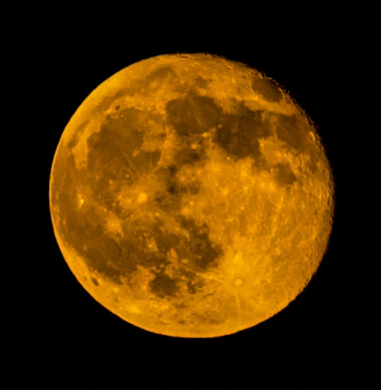 Full amber supermoon against black sky
